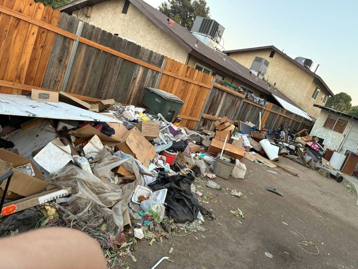 Alley and side yard piled with debris before removal